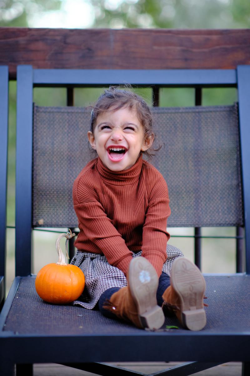 Little girl doubled over with laughter in a chair