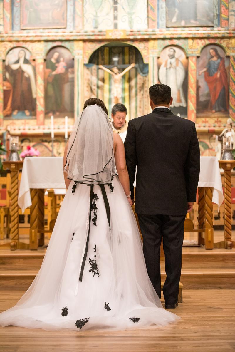 Couple seen from behind at a hand-painted chapel altar